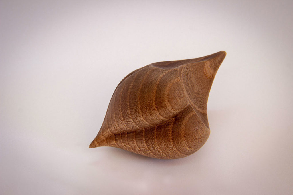 Front view of the turned sculpture: "Birdy love seed" (sensory and ergonomic sculpture in the hand, inspired by the shape of the heart, in dark walnut) - Original creation by Coralie Saramago