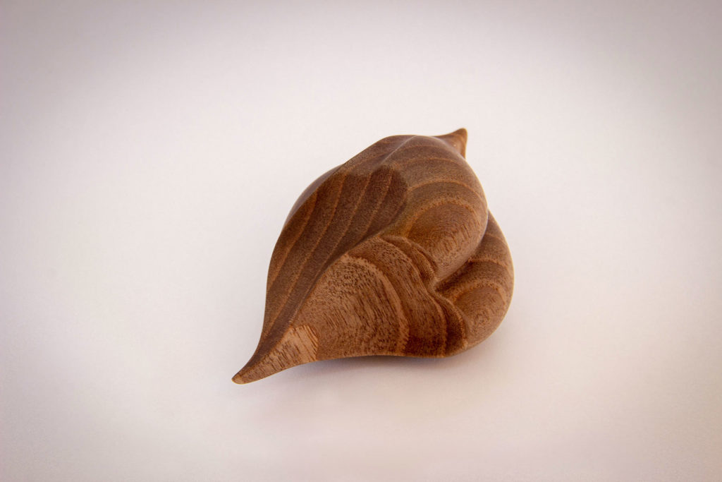 Top view (heart shape) of the turned sculpture: "Birdy love seed" (sensory and ergonomic sculpture in the hand, inspired by the shape of the heart, in dark walnut) - Original creation by Coralie Saramago