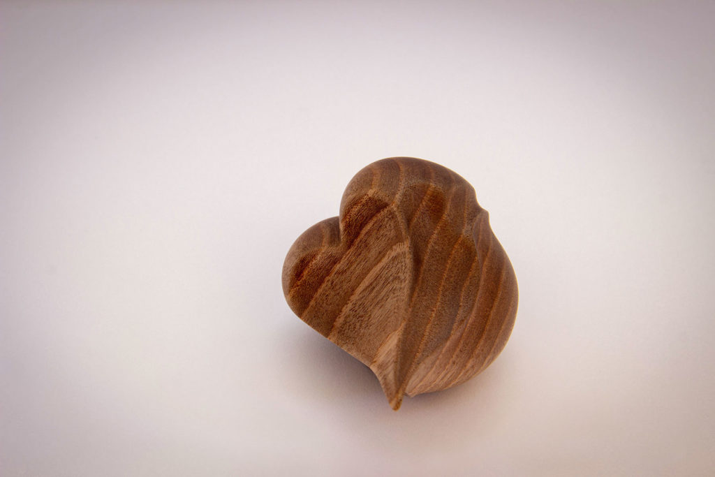 Top view (heart shape) of the turned sculpture: "Birdy love seed" (sensory and ergonomic sculpture in the hand, inspired by the shape of the heart, in dark walnut) - Original creation by Coralie Saramago