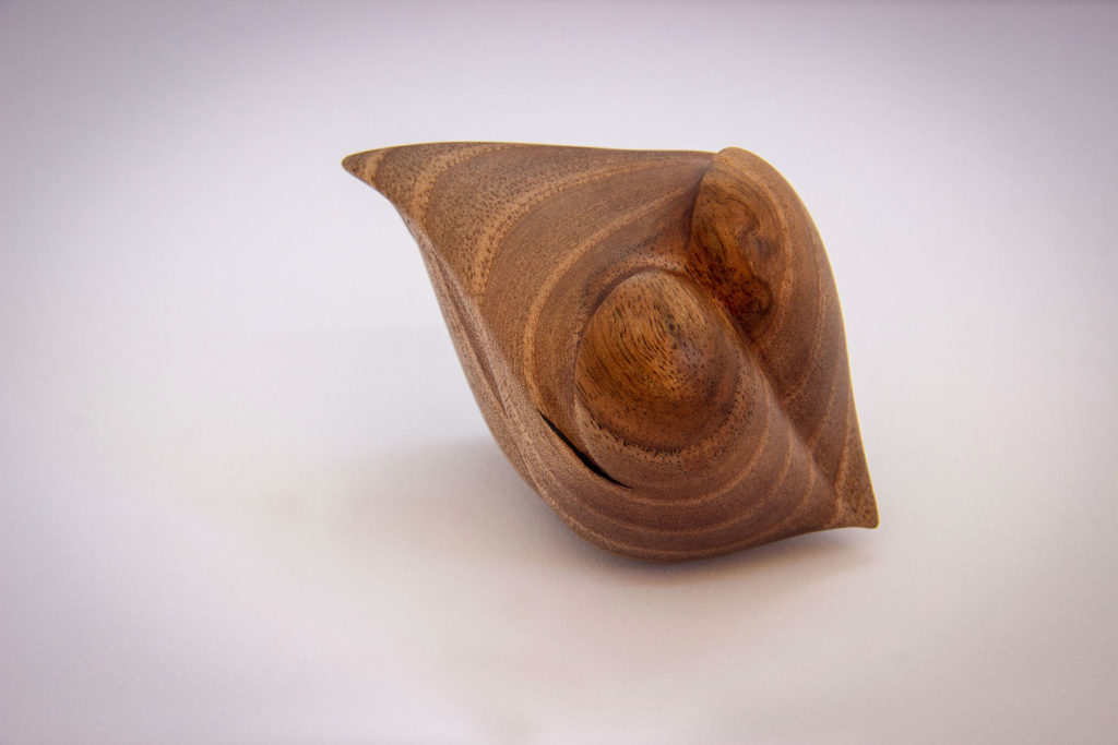 Overall view of the turned sculpture: "Corsage love seed" (sensory and ergonomic sculpture in the hand, inspired by the shape of the heart, in dark walnut) - Original creation by Coralie Saramago