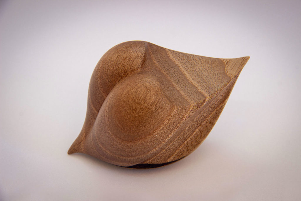 Overall view of the "love seed" sculpture (sensory and ergonomic sculpture in the hand, inspired by the shape of the heart, in dark walnut) - Original creation by Coralie Saramago